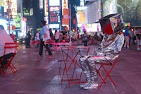 a man sitting in a chair on a city street