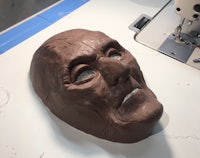 an old man's mask on a sewing machine