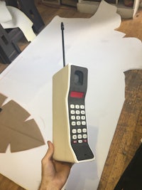 a person holding a phone in front of a piece of paper