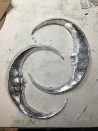 a pair of silver crescent moons on a table