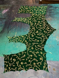 a green and gold pattern on a piece of fabric