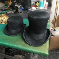 two black top hats sitting on a table
