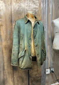 an old jacket on a mannequin in a room
