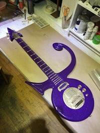 a purple guitar is sitting on a table in a workshop