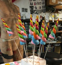 a mannequin with a unicorn horn on top of a cake