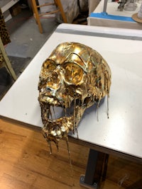 a gold skull sitting on a table in a workshop