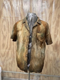 a mannequin with a dirty shirt on a mannequin stand