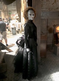 a woman in a black dress is standing in a room